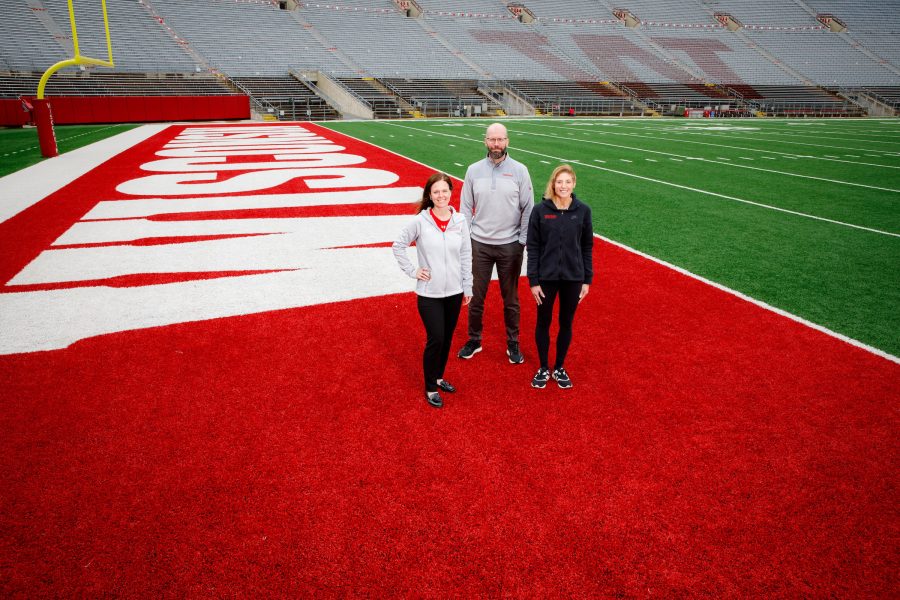 The BIOS lab leadership team standing in the red end zone of Camp Randall Stadium. Left to right: Maria Dehnert, Dr. Peter Miller, Dr. Sara Jimenez Soffa