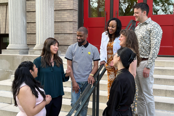 Group of scholars talking in a group outside the Red Doors