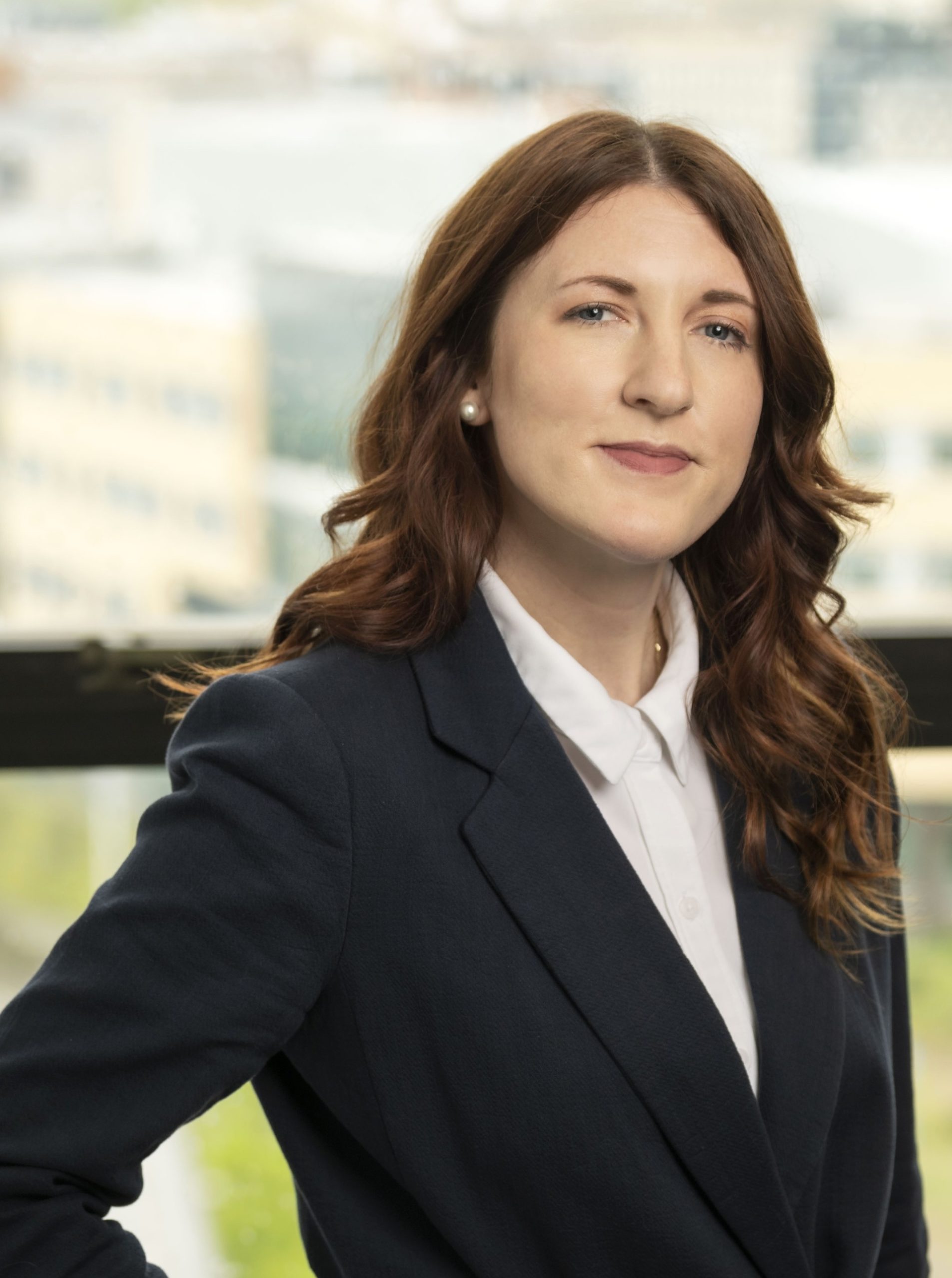 A headshot of Dr. Chelsea Blackburn Cohen, who is posing in front of window.